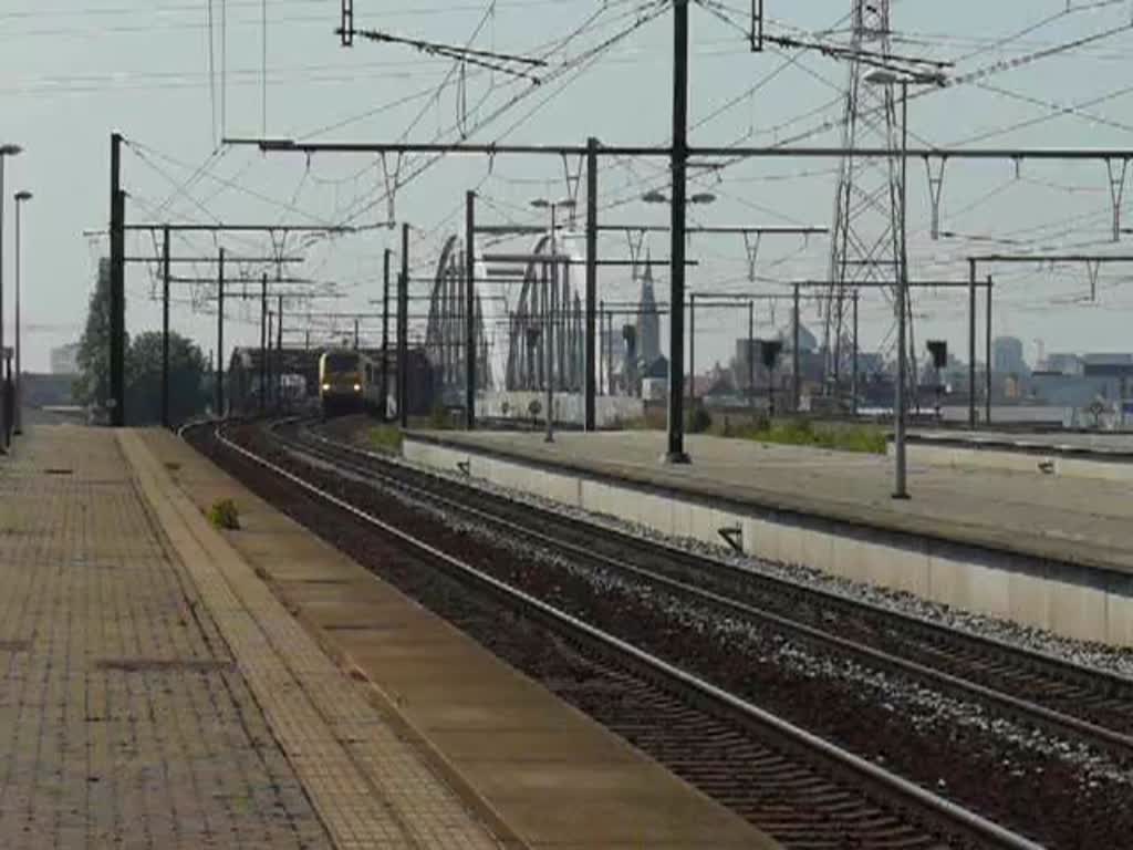 Doppeltraktion 1310 und 1311 ziehen einen langen mit Eisentrgern beladenen Gterzug ber das Gterverkehrsgleis durch den Bahnhof Antwerpen Luchtball. Im Hintergrund fhrt noch eine Lok der BR 13 mit Dostos vorbei und eine weitere Lok mit Personenzug rauscht durch den Bahnhaf. 23.06.10