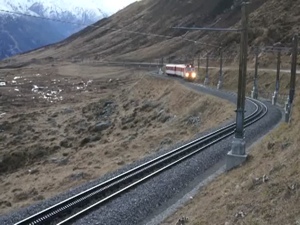 Oberalppass-Kanton Uri. Der Regionalzug R 852 der MGB Matterhorn Gotthardbahn von Andermatt kommend, mht sich die letzten paar hundert Meter bis zur Passhhe rauf. Dann geht es runter nach Disentis, wo er um 17:36 Uhr ankommen soll. Fahrzeit Andermatt-Disentis ist 1 Std. und 11 Min. 27.11.2011