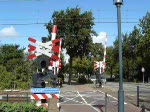 Die Bahnschranke in Etten-Leur schliesst, aber dann die Frage: aus welcher Richtung kommt der Zug? 
Lok 1744 mit RB fhrt aus Roosendaal kommend in Richtung Breda. 05.09.09