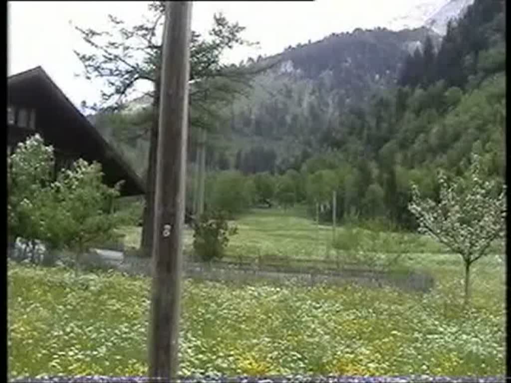 Berner Oberland 2004 (VHS-Archiv) - Ein  Traktor  bringt zwei Flachwagen am 26.05.2004 nach Blausee-Mitholz und in Kandersteg fhrt Re 460 002  Seeland  mit einem EC nach Mailand ein. Letzteres ist natrlich schon eine sehr historische Aufnahme, da italienische Reisezugwagen nicht mehr planmig ber den Ltschberg fahren.