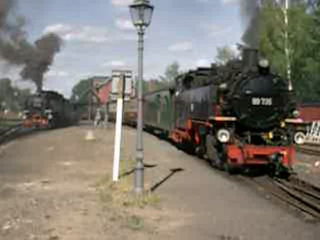 Doppelausfahrt nach KO Jonsdorf (Zug links mit 99 731) und KO Oybin (Zug rechts mit 99 735) in Bertsdorf. Die Steigung nach KO Jonsdorf hat es in sich, wie die Rauchentwicklung der 99 731 zeigt. 2003-08-27.