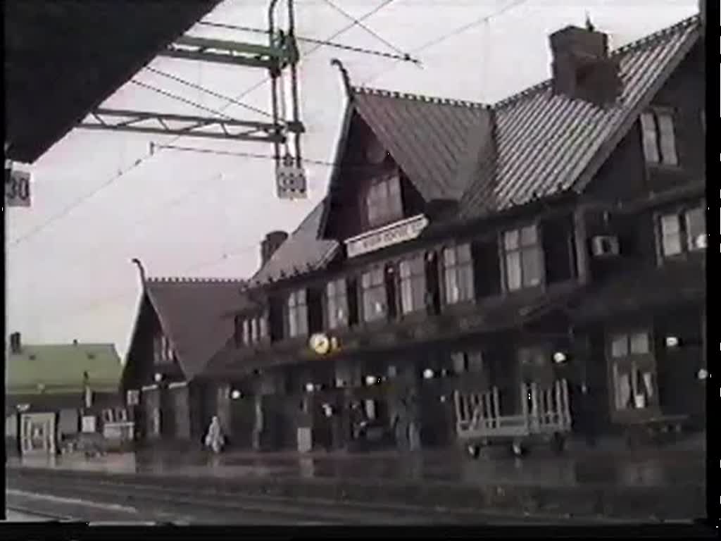 Ein schwerer Stahlzug mit Rc4 1255 und Rc5 1350 hält am 5. September 1992 in Boden am Bahnsteig, um einen Rangierer aufzunehmen. Deutlich ist zu sehen, wie sich vor der Wiederanfahrt das Lösen der Zugbremse unterschiedlich auswirkt. Die bereits ausgelöste Lok läuft zu den noch gebremsten Waggons zurück.