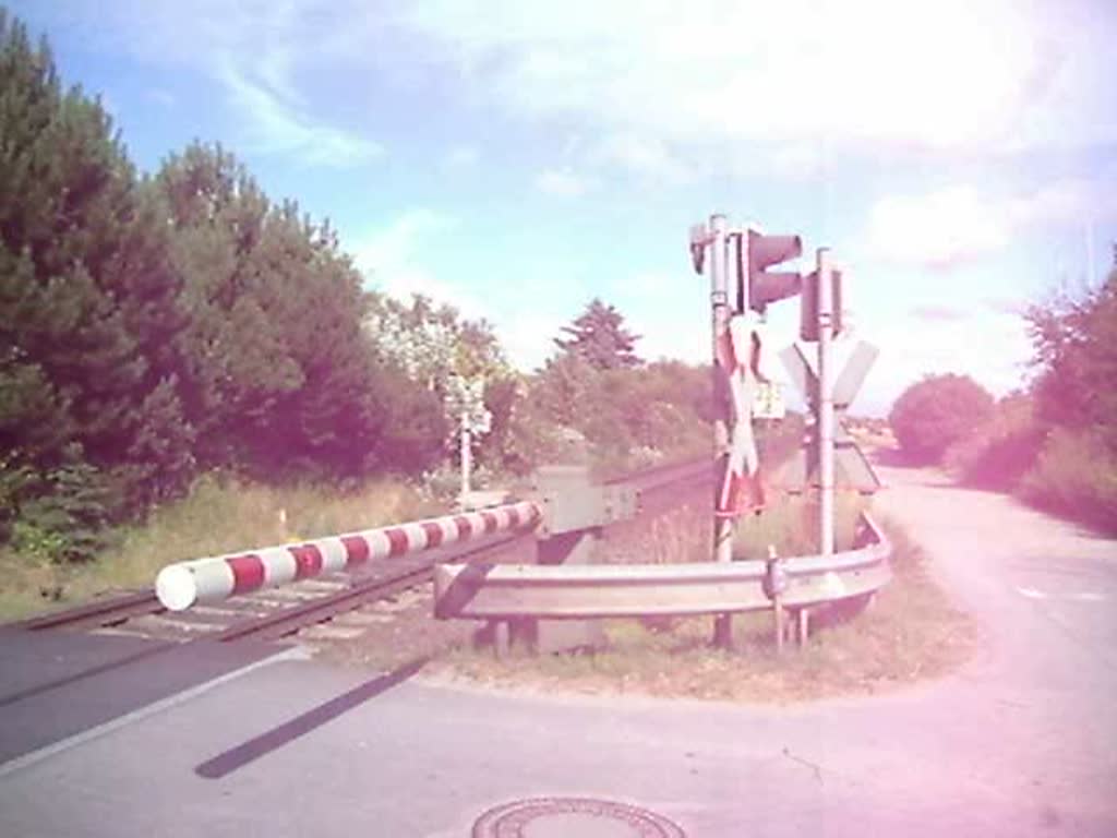 Eine ER20 fhrt mit einer NordOstseeBahn nach Westerland ber einen Bahnbergang in Tinnum