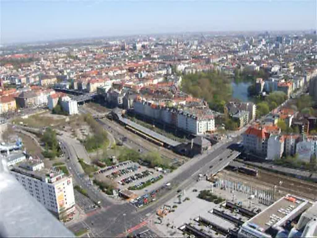 Eine S-Bahn vom Bahnhof Messe Nord-ICC zum Westkreuz. Gefilmt vom Messeturm, die Bahn ist nun naturgemss recht winzig. Das Gebude im Vordergrund ist ein Teil der Messebauten.