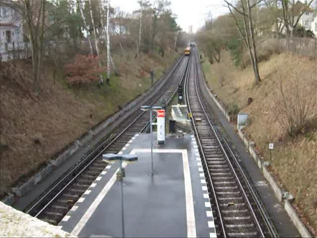 Einfahrender U-Bahnzug in den Bahnhof Dahlem Dorf. Der Zug kommt von Thielplatz und fhrt bis zum bernchsten Bahnhof (Podbielskiallee) als Einschnittbahn, d.h. aus Kostengrnden wurde auf den Tunnelbau verzichtet. U.U. plante man den Einschnitt spter zu berbauen,falls der Lrm fr die Anwohner zu gross wre.