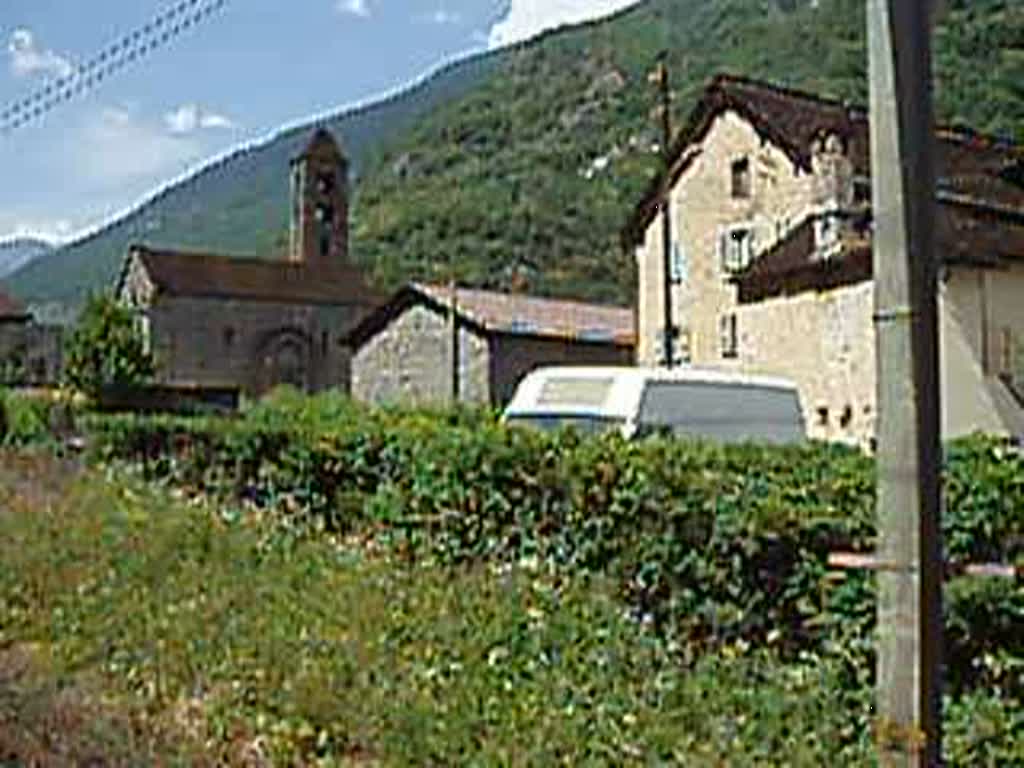 Interregio-Zug Locarno-Zrich fhrt in Giornico TI gerade an der Kirche San Nicolao (12. Jh.) vorbei