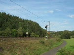 212 097-0 der DBG legt sich mit einem Bauzug zwischen Bad Hersfeld und Haunetal Neukirchen in die Kurve.