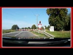 Annäherung per Strasse an den geschlossenen Bahnübergang in Borckenfriede. Nun beginnt das vermeintlich lange Warten darauf, daß der Bahnübergang wieder freigegeben wird. Zusehen ist der RE 3 von Stralsund kommend, der den Bahnübergang innerhalb von wenigen Sekunden verlassen hat. - Sommer 2018