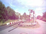 Eine ER20 fhrt mit einer NordOstseeBahn nach Westerland ber einen Bahnbergang in Tinnum