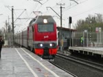 EP2K-151 fährt mit einem langen Reisezug durch den Bahnhof Kolpino in Richtung St.