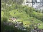 Berner Oberland 2004 (VHS-Archiv) - Oberalb von Lauterbrunnen knnen wir an der gegenberliegenden Bergseite die Zge der Wengernalpbahn beobachten. Zei Gterzge sind talwrts unterwegs. Das rauschen kommt von einem Bergbach direkt neben uns. 24.05.2004.