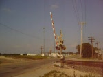 Bahnbergang mit herannahendem BNSF Gterzug (Dash-9 Lokomotive)in Rose Hill, Kansas im April 2006